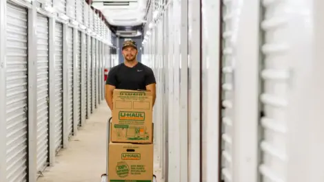 View of man pushing boxes in hallway of Kenosha, WI Superior Storage facility.